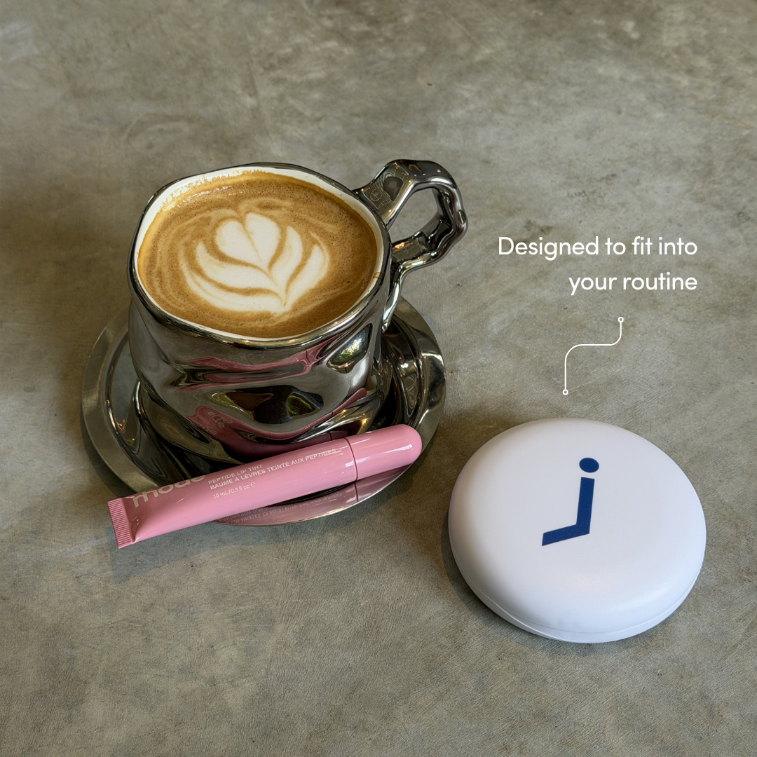Cappuccino in a silver cup with a pink lip balm and white aligner ase with blue 'jawology' logo on it.
